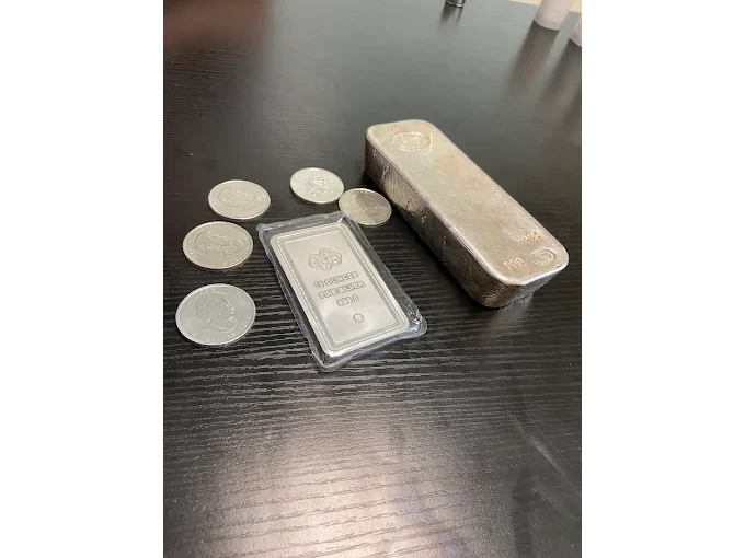 Silver rounds and a silver bar on a desk