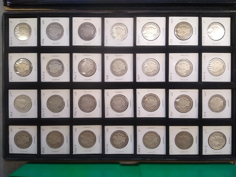 A tray of silver dimes and quarters in coin flips on a green felt case