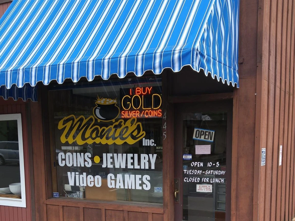The blue striped awning and I Buy Gold, Silver, Coins window sign at Monte's Coins & More