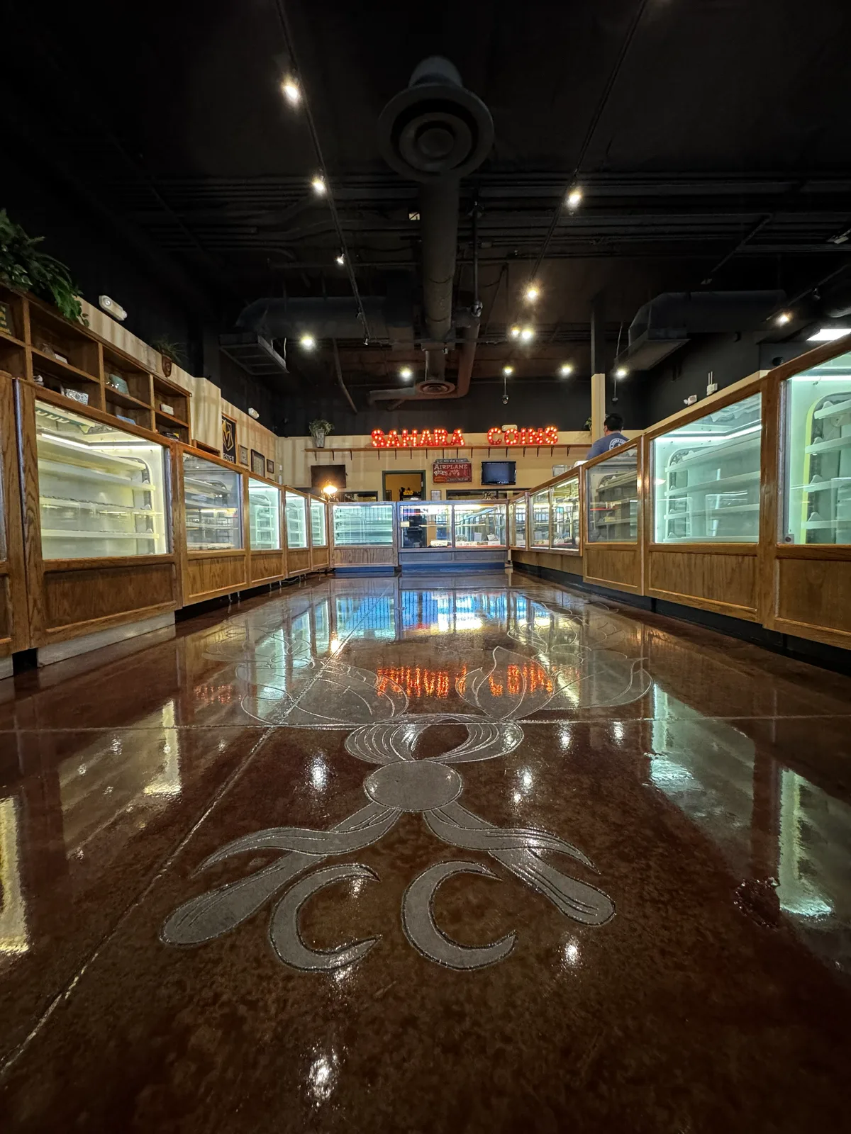Interior of Sahara Coins & Precious Metals in Las Vegas, showing the lit SAHARA COINS sign and wooden display cases